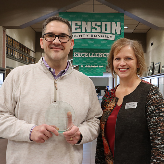 Principal and representative hold award in Benson hallway
